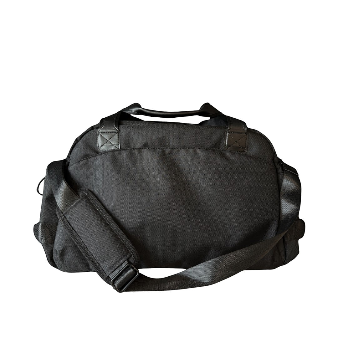BirdieBox black nylon duffle bag with leather handles and adjustable shoulder strap, perfect for travel or gym.