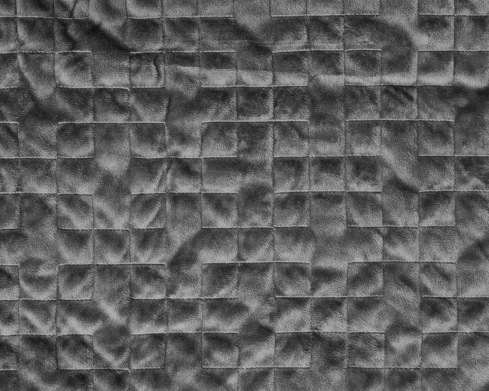 BirdieBox Gravity Original grey micro-plush weighted blanket with gridded stitching and glass beads.