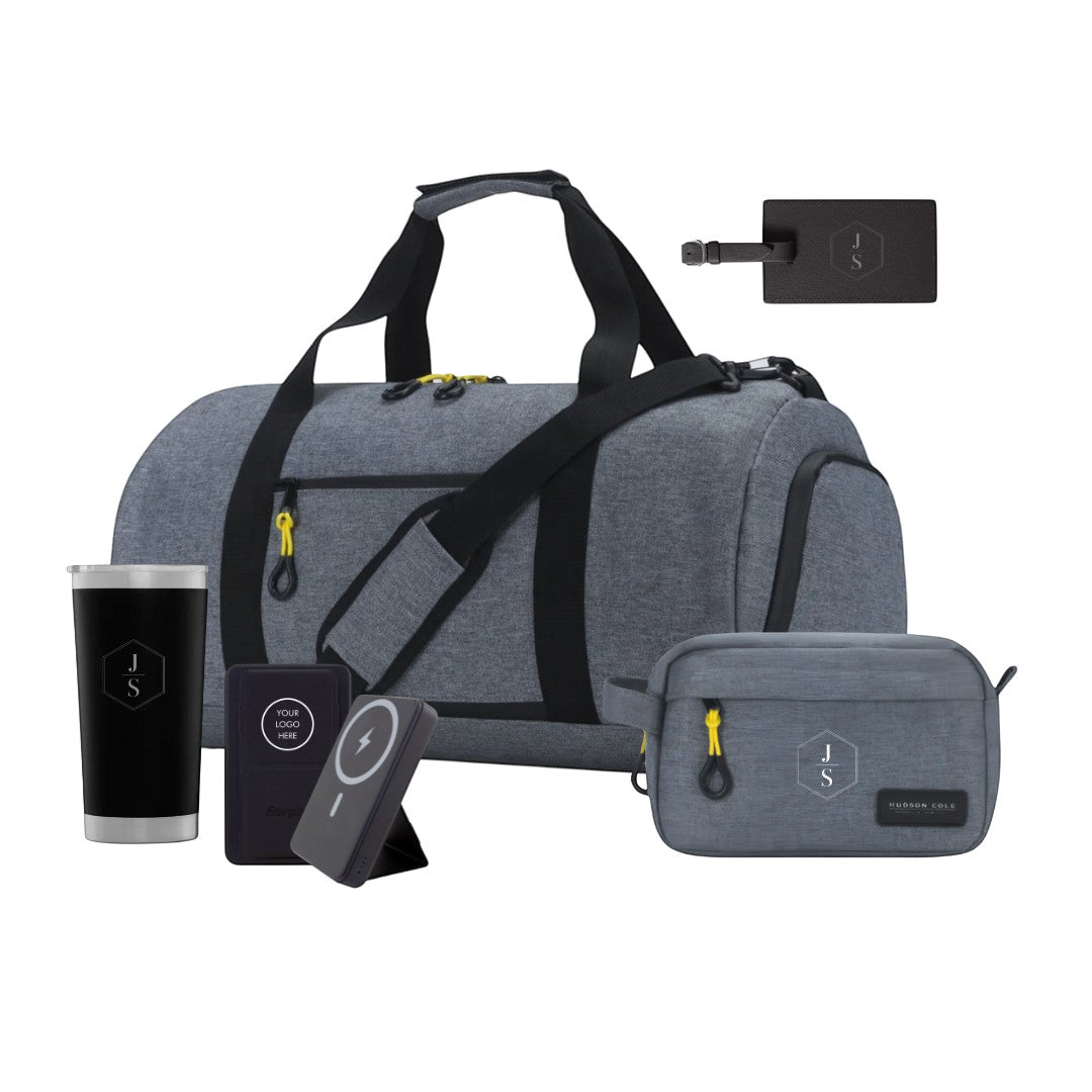 BirdieBox Hit the Road Gift Set: dark grey canvas duffle, dopp kit, black tumbler, power bank, and luggage tag.