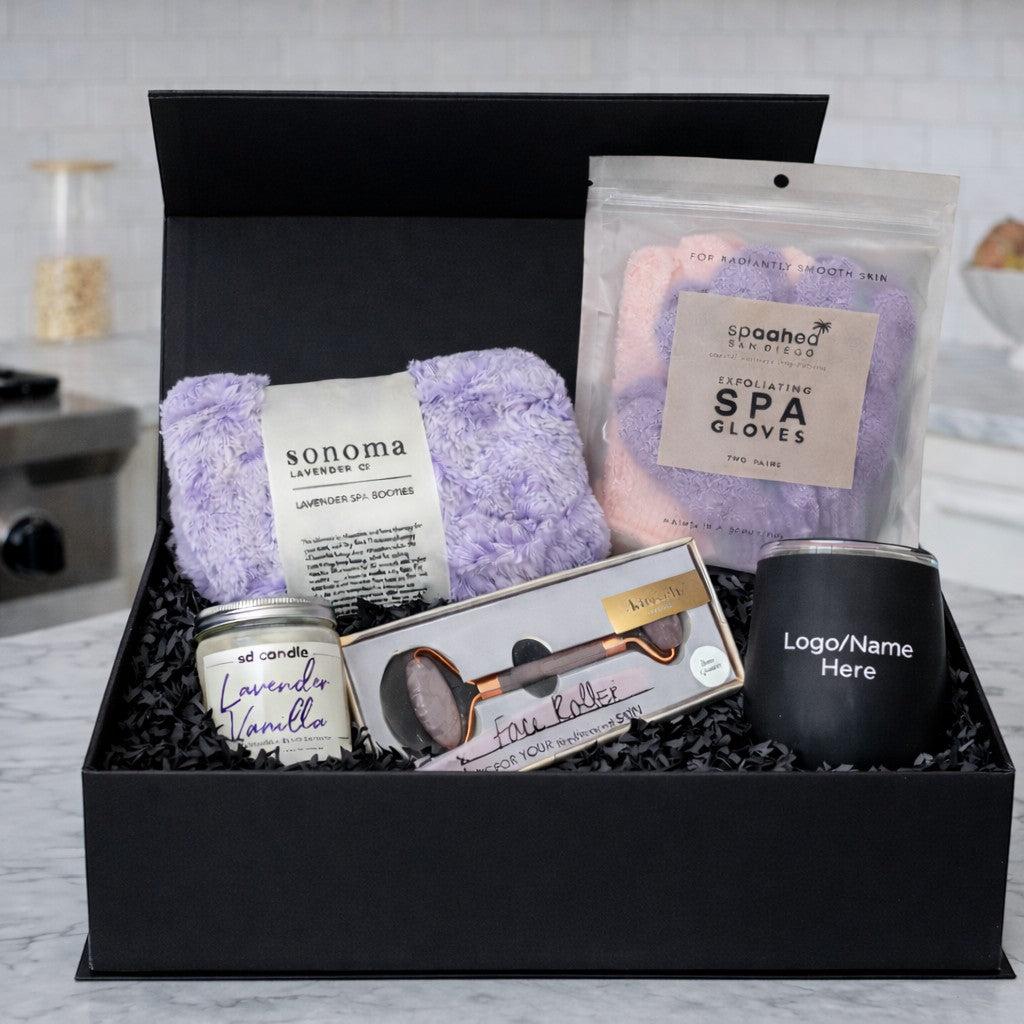 BirdieBox curated wellness gift set with lavender spa booties, spa gloves, candle, face roller, and customizable mug in a black gift box.