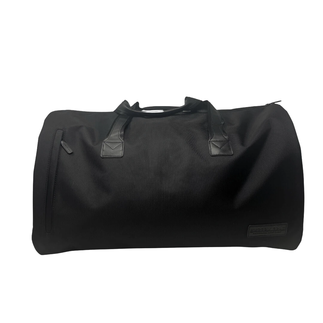 BirdieBox Hudson Cole black canvas garment bag and duffel with leather handles and exterior zip pocket.