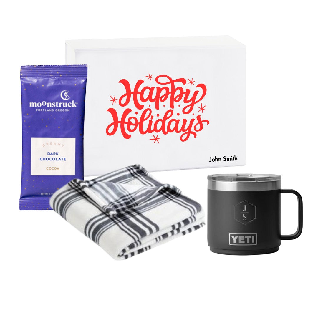 BirdieBox Home for the Holidays gift set featuring a black YETI mug, black and white plaid blanket, and Moonstruck dark chocolate cocoa.