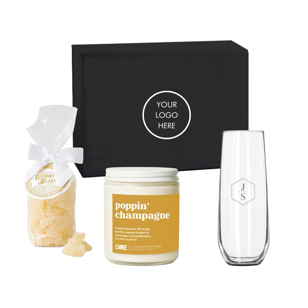 BirdieBox Toast to You Gift Set: stemless champagne flute, champagne candle, prosecco gummy bears, and personalized letter in a black gift box.