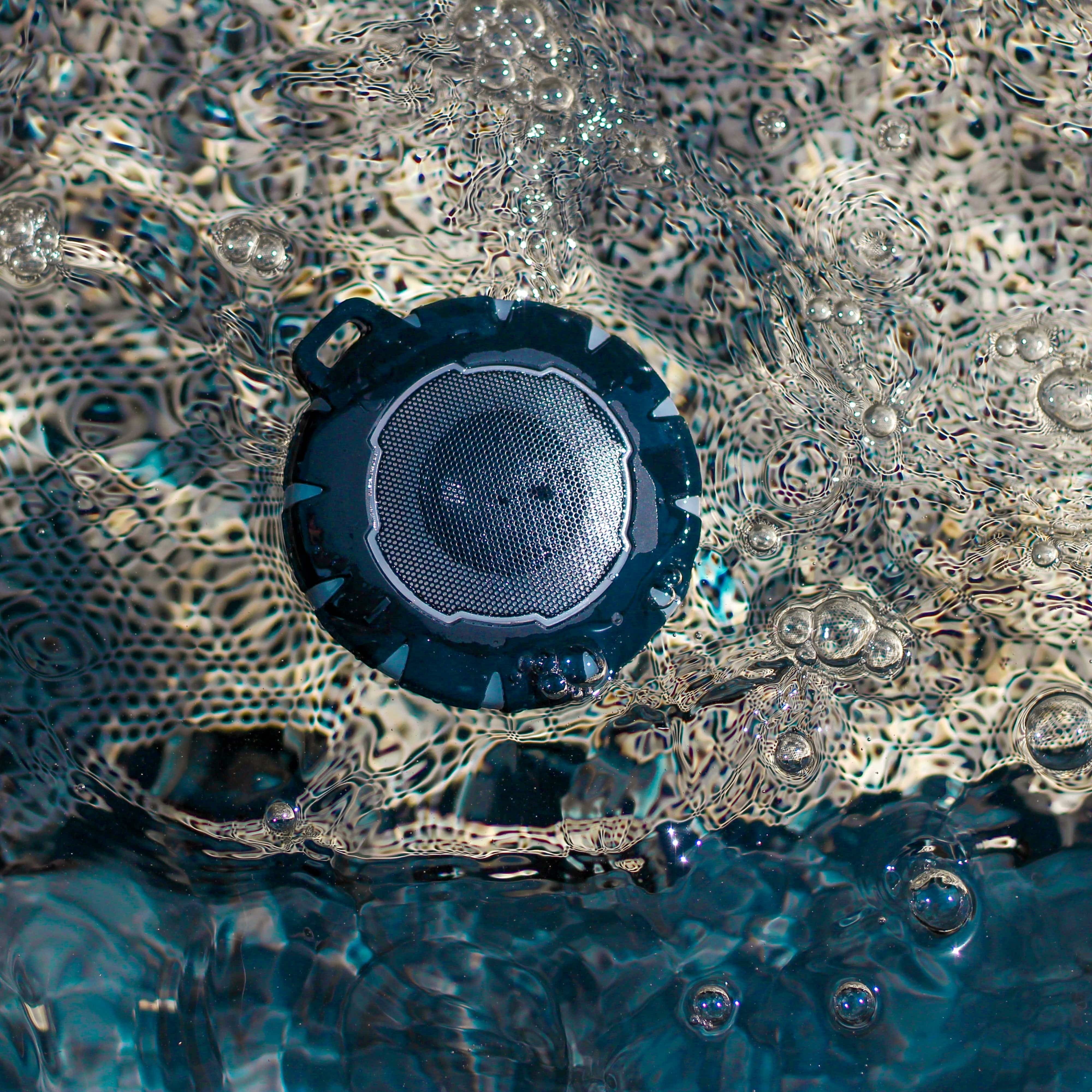 BirdieBox BBTEK waterproof Bluetooth speaker with lightshow feature submerged in water with bubbles.