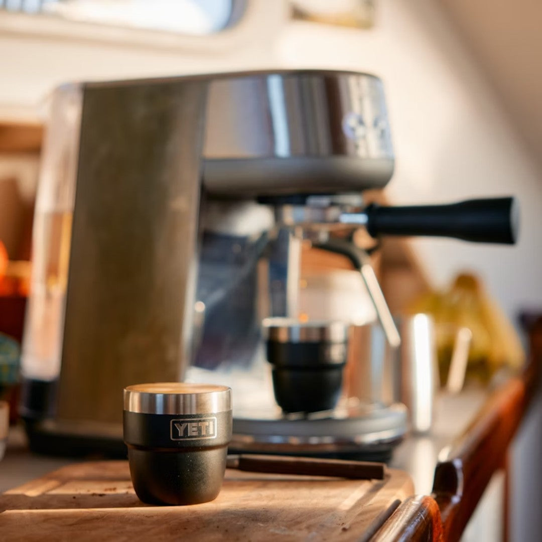 BirdieBox YETI Rambler 4 oz stackable espresso cups in black with silver lid, next to an espresso machine.